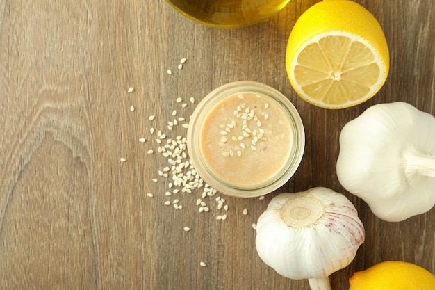 Konzept des leckeren Essens mit Tahini-Sauce auf hellem Holzhintergrund