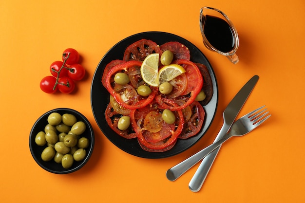 Konzept des leckeren Essens mit Tomatencarpaccio auf orangefarbenem Hintergrund