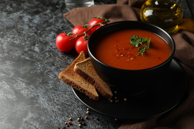 Konzept des leckeren Essens mit Tomatensuppe auf schwarzem Rauch