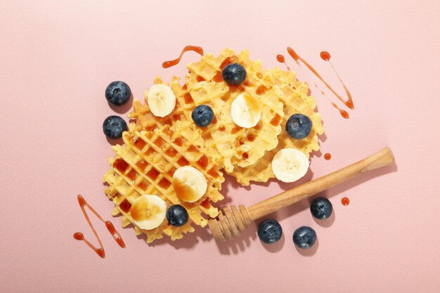 Konzept des leckeren Essens mit Waffeln auf rosa Hintergrund