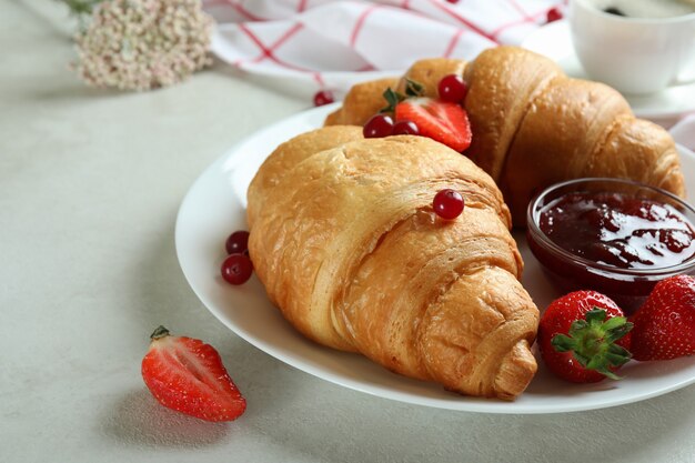 Konzept des leckeren Frühstücks mit Croissants auf weiß strukturiertem Tisch