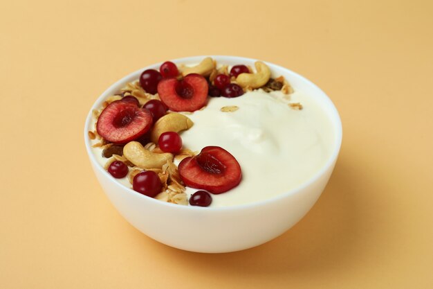 Konzept des leckeren Frühstücks mit Joghurt auf beigem Hintergrund