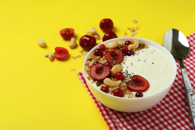 Konzept des leckeren Frühstücks mit Joghurt auf gelbem Hintergrund