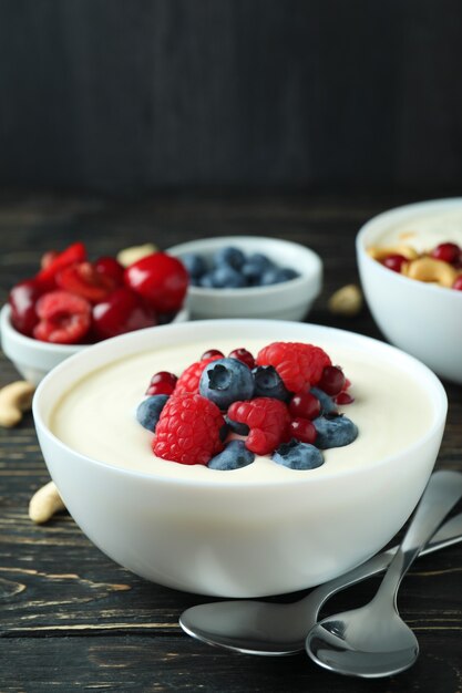 Konzept des leckeren Frühstücks mit Joghurt auf Holztisch