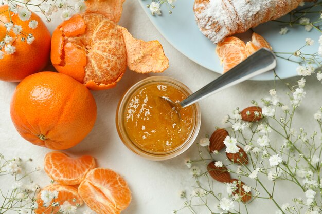 Konzept des leckeren frühstücks mit mandarinenmarmelade auf weißem strukturiertem tisch