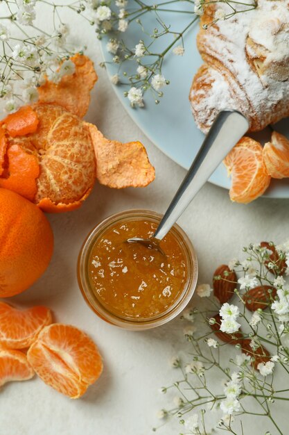 Konzept des leckeren Frühstücks mit Mandarinenmarmelade auf weißem strukturiertem Tisch