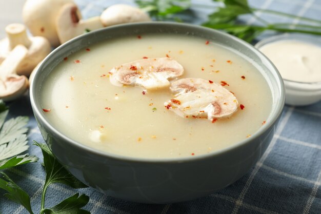 Konzept des leckeren Mittagessens mit Schüssel Pilzsuppe auf Serviettenhintergrund