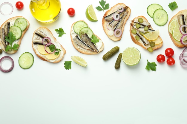 Konzept des leckeren Snacks mit Sandwiches mit Sprotten auf weißem Hintergrund