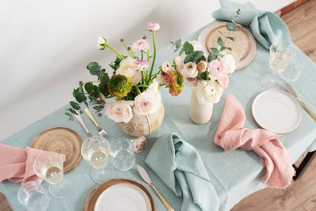 Konzept des romantischen Ostertischs mit Blumen und hellgrünem Bild mit selektivem Fokus der Tischdecke