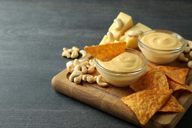 Konzept des Snacks mit Käsesauce auf dunklem Holztisch