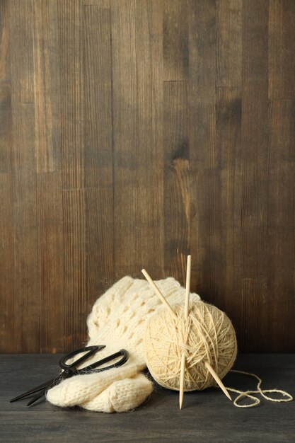 Konzept des Strickens mit Garnknäuel auf grauem Holztisch