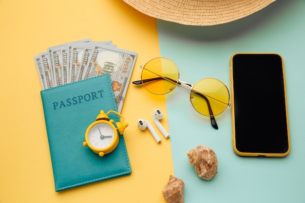 Konzept des Tourismus. Reiseaccessoires und Reisepass mit Geld auf gelbblauer Oberfläche