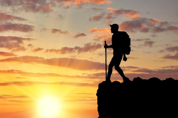 Konzept des Tourismus. Silhouetten von Touristen auf einem Berg vor dem Hintergrund eines wunderschönen Sonnenuntergangs