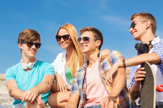 Konzept Freundschaft, Freizeit, Sommer und Menschen - Gruppe lächelnder Freunde mit Skateboard auf der Straße der Stadt