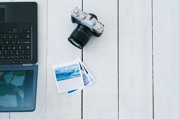 Konzept für digitale Fotografie und Fotobearbeitung. Laptop-Kamera und gedruckte Aufnahmen auf Weiß.