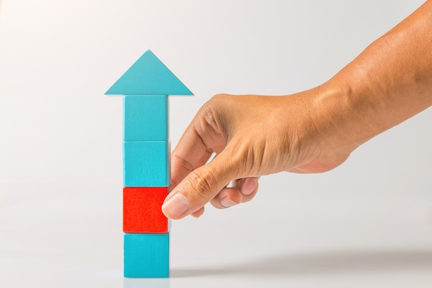 Konzept für Geschäftsunterbrechungsideen. Mannhand, die roten Holzblock vom blauen Holzblock zieht