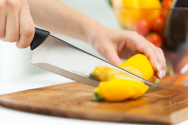 Konzept für gesunde Ernährung, Kochen, vegetarisches Essen, Gemüse und Menschen - Nahaufnahme von Frauenhänden, die Kürbis mit Messer hacken