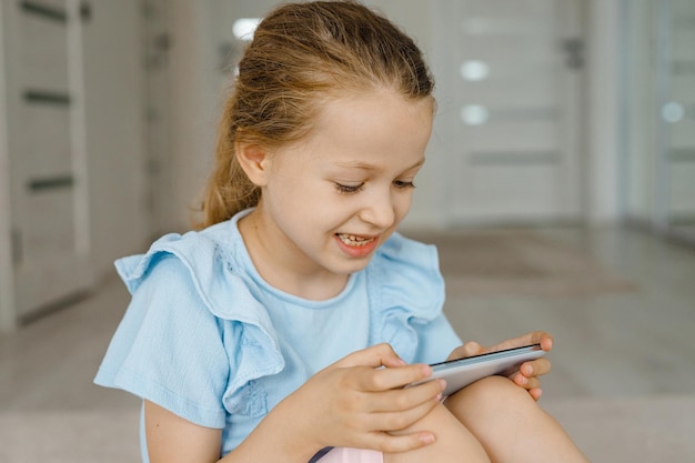 Konzept für Kinder und elektronische Geräte Porträt eines Kleinkindes mit Smartphonekleines Mädchen mit digitalem Tablet zu Hause Kind mit Gadgets zum Lernen