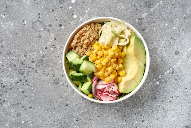 Konzept gesunde vegane Mittagsschüssel. Avocado-, Quinoa-, Tomaten-, Gurken- und Rettich-Gemüsesalat. Ansicht von oben. Lieferservice, Essen zum Mitnehmen