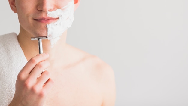 Konzept mit attraktivem jungem Mann rasieren