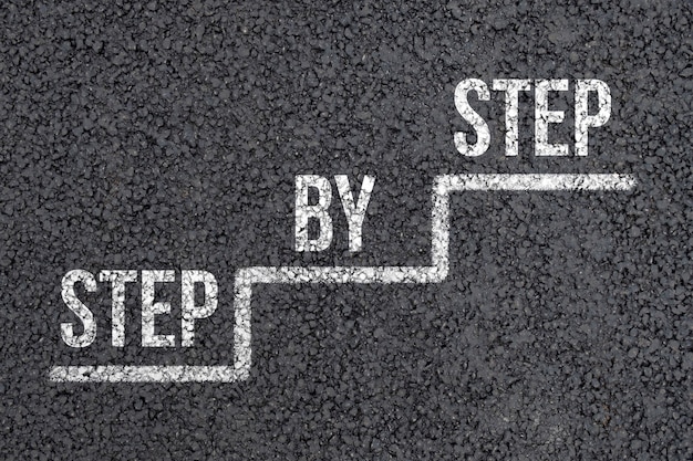 Konzept Schritt für Schritt auf einer abstrakten Treppe auf dem Asphalt.