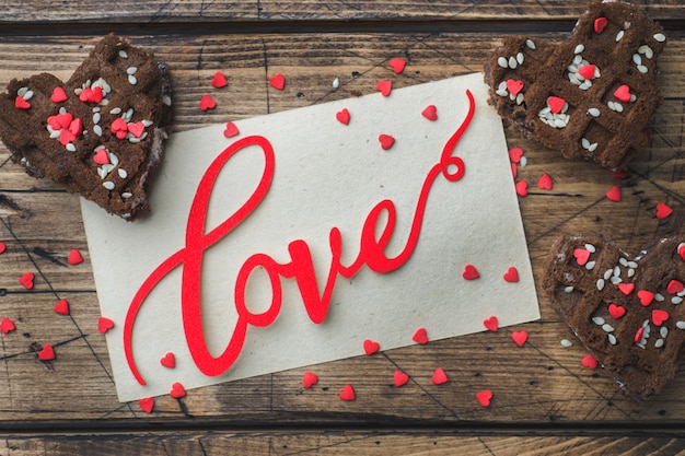 Konzept Valentinstag. Schokoladenkekse auf einem Holztisch. Grußkarte.