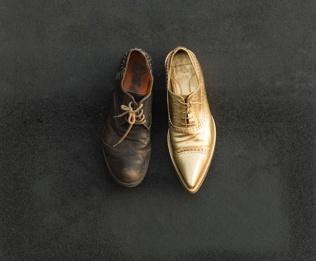 Konzept von Arm und Reich in einem alten und goldenen Schuh