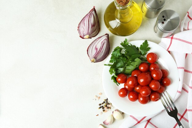 Konzept von eingelegtem Gemüse mit Tomaten auf weißem strukturiertem Tisch