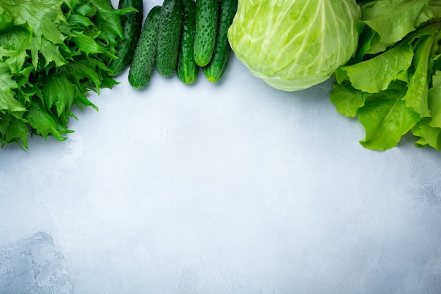 Konzept von frischem grünem Salat, Kohl, Gurke, Dill, Limette auf einem Leuchttisch. Selektiver Fokus. Gesunde rohe Bio-Lebensmittel. Draufsicht. Speicherplatz kopieren.