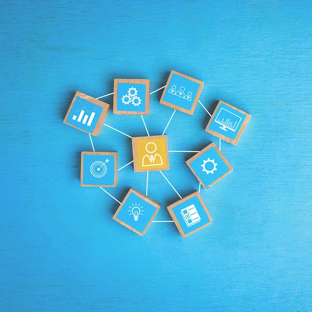 Konzept von Führungskräften in Unternehmensorganisationen mit Personalmanagement und Finanzen, Marketing, Informationen. Holzblock mit Symbol auf blauem Hintergrund