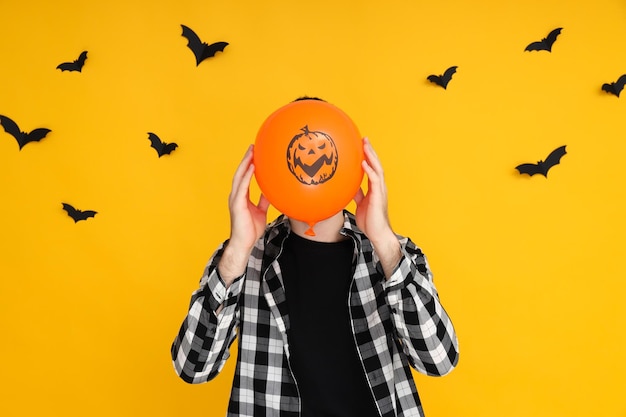 Konzept von Halloween Guy mit Halloween-Ballon auf gelbem Hintergrund