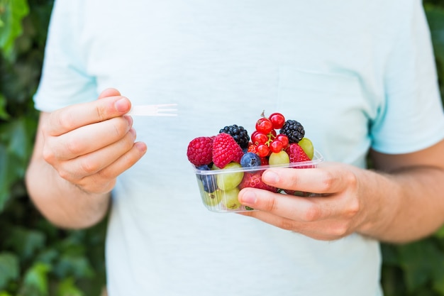 Konzept von Vegetariern, Rohkost und Diäten - Nahaufnahme des Menschen hält Früchte und Beeren.