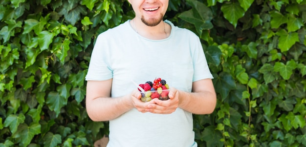 Konzept von Vegetariern, Rohkost und Diäten - Nahaufnahme des Menschen hält Früchte und Beeren.