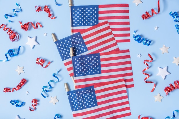 Konzept zum Unabhängigkeitstag der USA USA-Flaggen und rote und blaue Spiralen und weiße Sterne Draufsicht flach auf blauem Hintergrund liegend