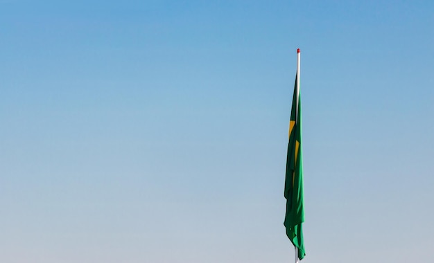 Konzeptbild einer brasilianischen Flagge auf der Stange ohne Wind vor blauem Himmel