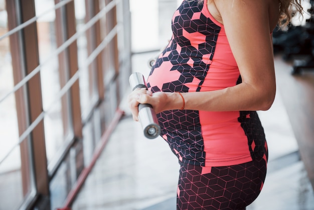 Foto konzeption von schwangerschaft, sport, fitness und gesundem lebensstil im fitnessstudio.