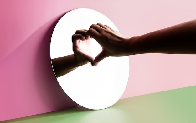 Konzeptionell für Liebe und Beziehung Liebe dich selbst Person mit der Hand, um eine Herzform auf dem Spiegel zu bilden