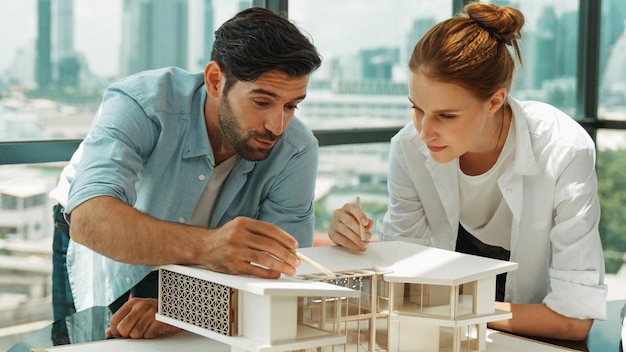 Foto kooperatives ingenieurenteam arbeitet zusammen, um das hausmodell tracery zu messen