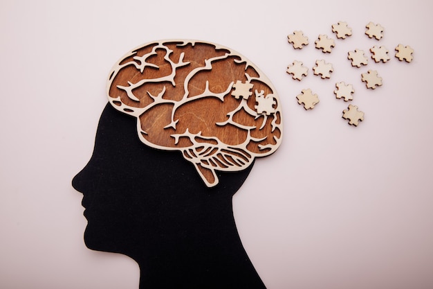 Kopf des Mannes mit Gehirn und Holzpuzzle. Konzept für Alzheimer, Demenz und psychische Gesundheit.