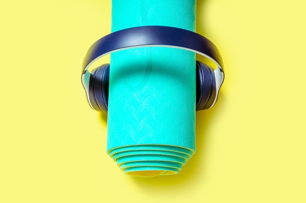Kopfhörer mit Sportausrüstung und Yogamatte hören Musik