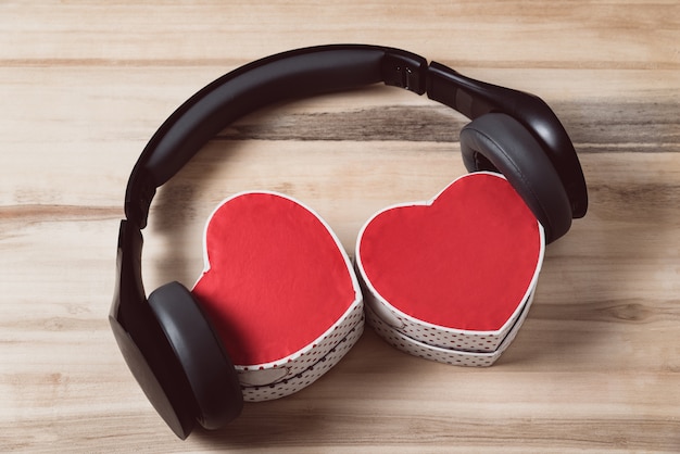 Kopfhörer und zwei Geschenkboxen in Form eines Herzens. Musik der Herzen. Ansicht von oben