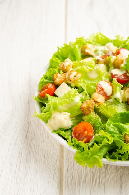 Kopfsalat-Tomaten-Käse-Salat-Croutons-Dressing Weißer Hintergrund