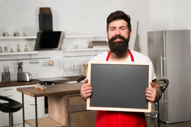 Kopieren Sie Platz an seinem Brett Mann Koch mit Brett kopieren Platz Reifer Mann Bärtiger Mann Koch Restaurant oder Café-Menü Anzeige Hipster in der Küche Bärtiger Mann in roter Schürze Bereit zum Kochen