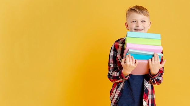 Foto kopierraum kleiner junge mit stapel bücher