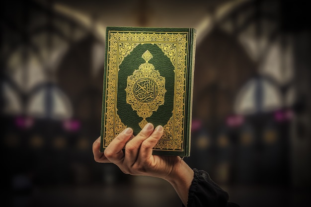 Koran in der Hand - heiliges Buch der Muslime