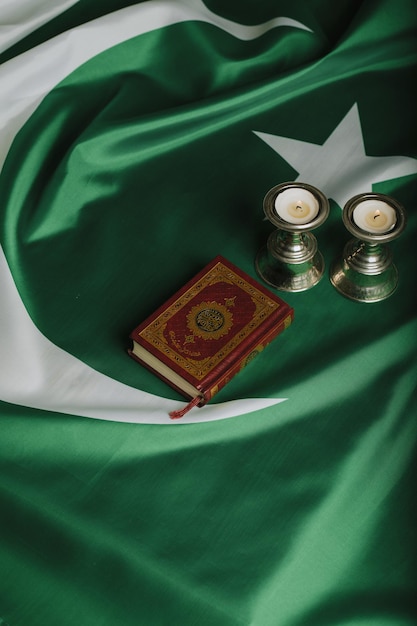 Koran und Kerzen auf einer Flagge Pakistans