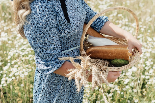 Foto korb mit brotmilch und weizenähren in den händen der jungen frau