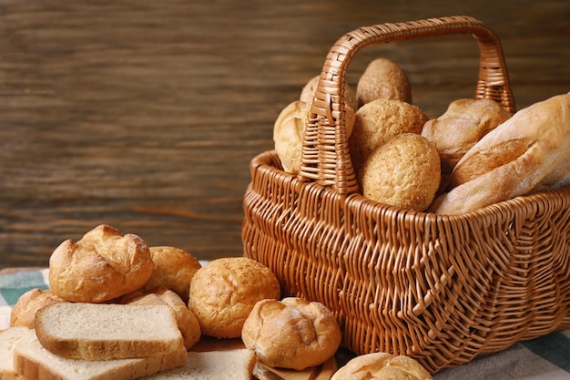 Korb mit unterschiedlichem Brot auf hölzernem Hintergrund