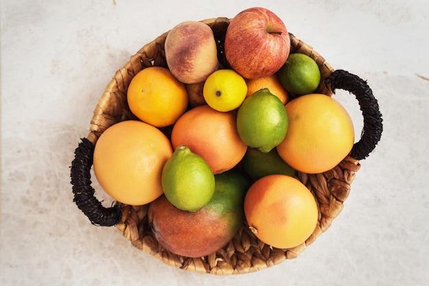 Korb mit vielen verschiedenen Früchten wie Apfel, Pfirsich, Orange, Zitrone, Grapefruit und Mango