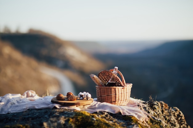 Korb mit Wein und Baguette und Holztablett mit Croissants